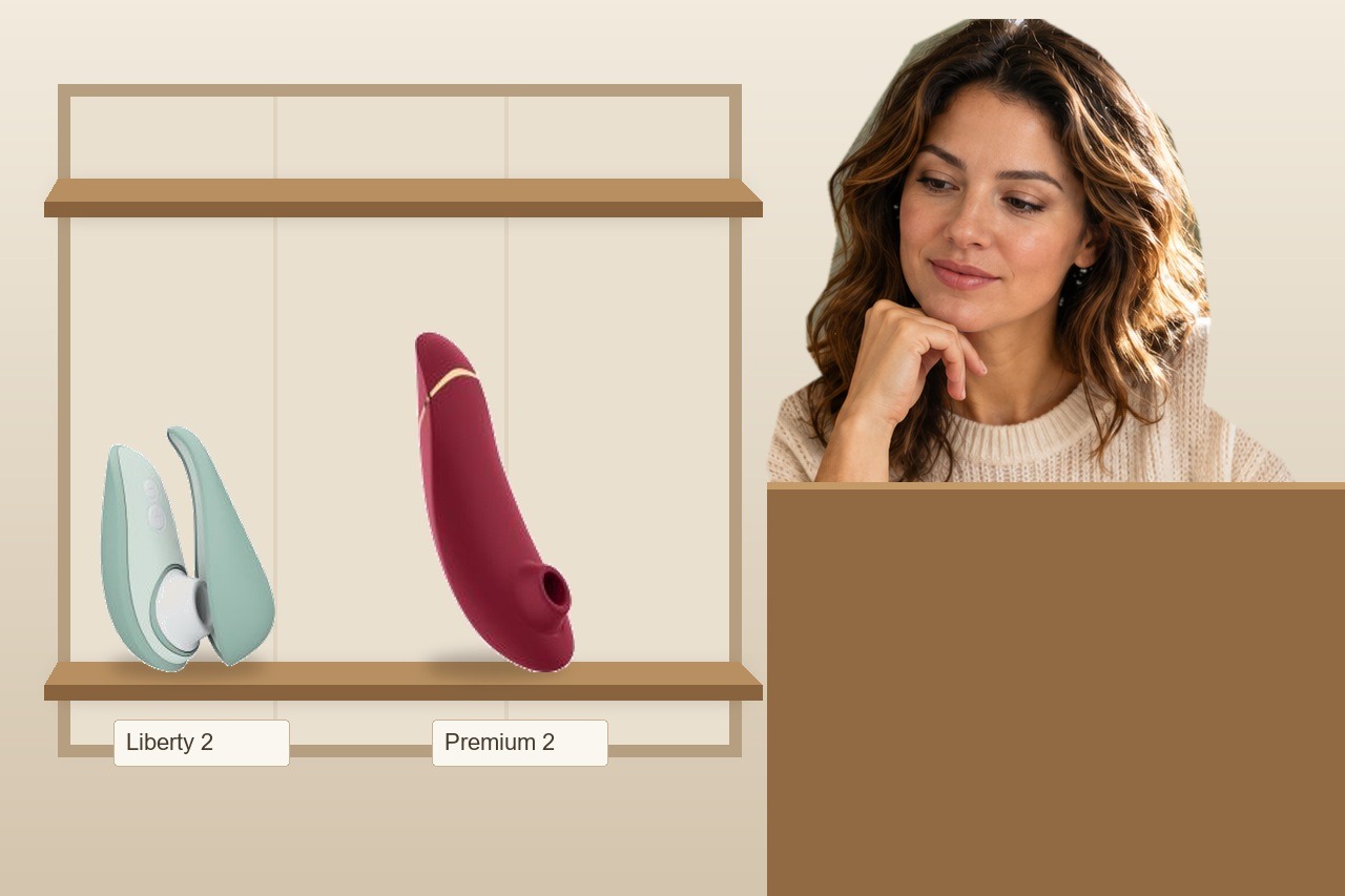 Womanizer Liberty 2 et Premium 2 — choix en boutique Une femme compare le Womanizer Liberty 2 sauge et le Premium 2 bordeaux présentés sur une étagère en boutique.